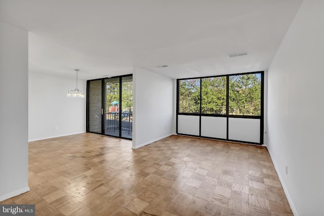 523 N Armistead St Unit 102, Alexandria, VA 22312 - empty room with floor to ceiling windows, a chandelier, baseboards, and healthy amount of natural light