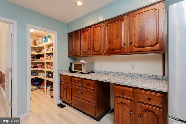 1492 Cumberland Dr, Rockingham, VA 22801 - kitchen featuring freestanding refrigerator, light wood-type flooring, brown cabinetry, and recessed lighting