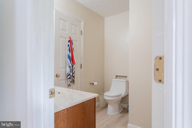 1492 Cumberland Dr, Rockingham, VA 22801 - half bath with vanity, toilet, wood finished floors, baseboards, and a textured ceiling