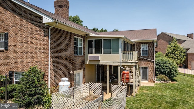 1492 Cumberland Dr, Rockingham, VA 22801 - back of house featuring a sunroom, brick siding, a chimney, and a lawn