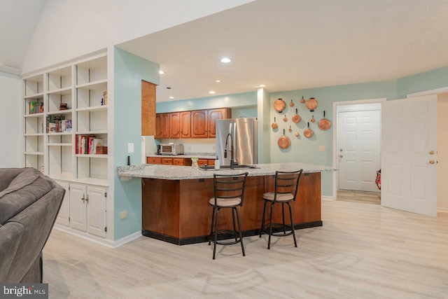 1492 Cumberland Dr, Rockingham, VA 22801 - kitchen with a sink, freestanding refrigerator, light wood finished floors, a breakfast bar, and a peninsula