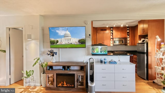 7333 New Hampshire Ave Unit 800, Takoma Park, MD 20912 - kitchen featuring appliances with stainless steel finishes, brown cabinets, light wood finished floors, dark countertops, and open shelves