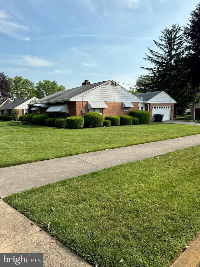 228 S Forge Rd, Palmyra, PA 17078 - view of home's exterior featuring asphalt driveway, a lawn, brick siding, and a garage