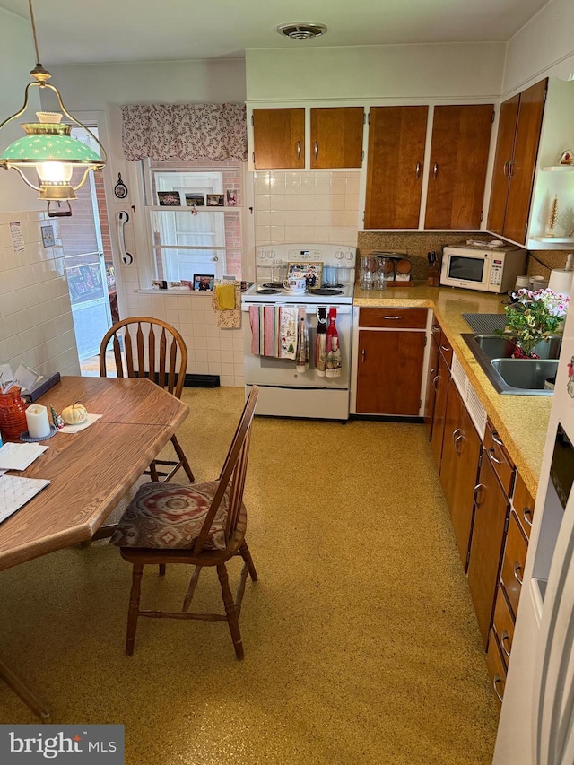 228 S Forge Rd, Palmyra, PA 17078 - kitchen featuring white appliances, brown cabinetry, a sink, tile walls, and light countertops