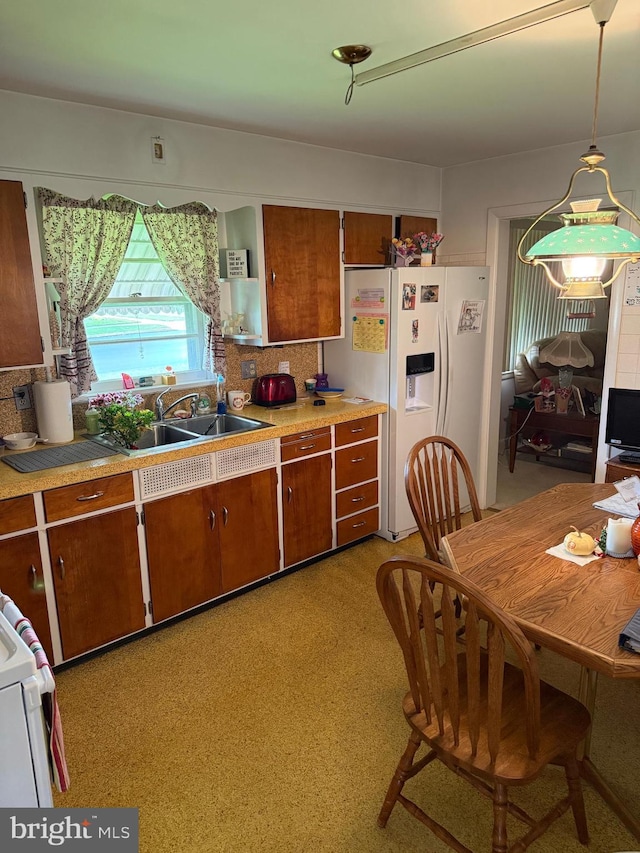 228 S Forge Rd, Palmyra, PA 17078 - kitchen featuring white refrigerator with ice dispenser, a sink, light countertops, tasteful backsplash, and brown cabinets