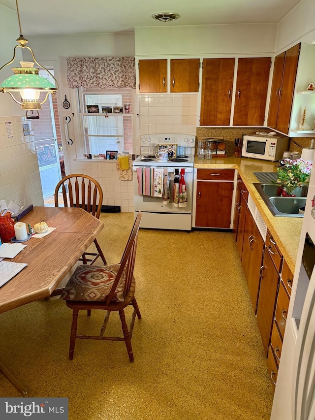 228 S Forge Rd, Palmyra, PA 17078 - kitchen featuring white appliances, tile walls, brown cabinetry, a sink, and light countertops