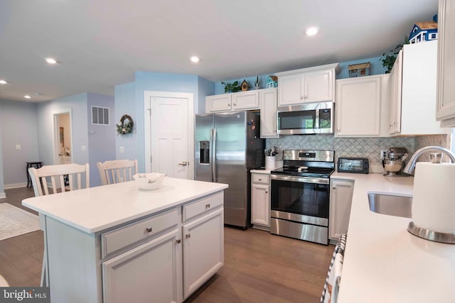 189 Massie St, Stephens City, VA 22655 - kitchen featuring appliances with stainless steel finishes, dark wood finished floors, decorative backsplash, light countertops, and a sink