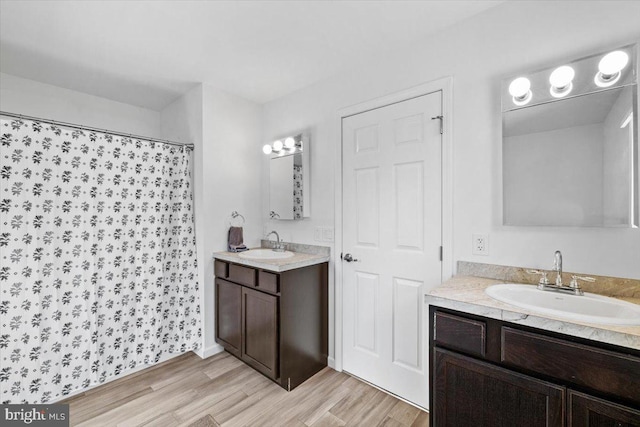 228 Cranberry Dr, Blakeslee, PA 18610 - bathroom featuring wood finished floors, two vanities, and a shower with shower curtain