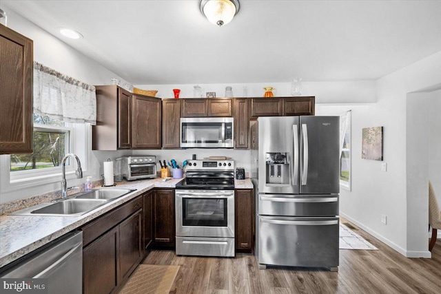 228 Cranberry Dr, Blakeslee, PA 18610 - kitchen with appliances with stainless steel finishes, a sink, wood finished floors, light countertops, and dark brown cabinets