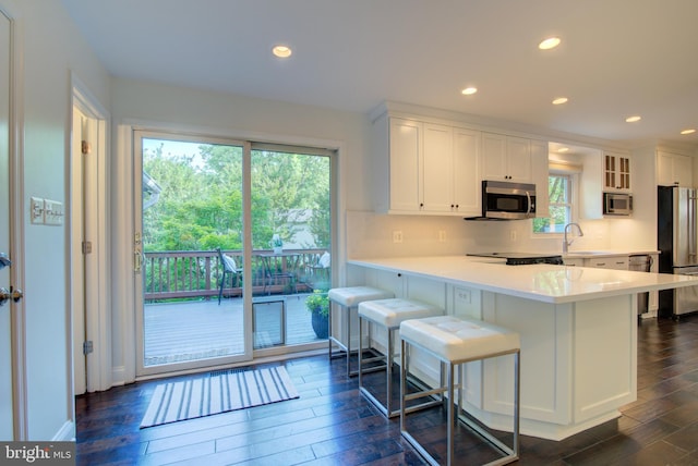 12013 Cheviot Dr, Herndon, VA 20170 - kitchen with stainless steel appliances, dark wood-type flooring, white cabinets, light countertops, and recessed lighting