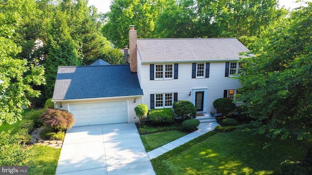 12013 Cheviot Dr, Herndon, VA 20170 - colonial inspired home featuring a garage, a chimney, concrete driveway, and a front yard