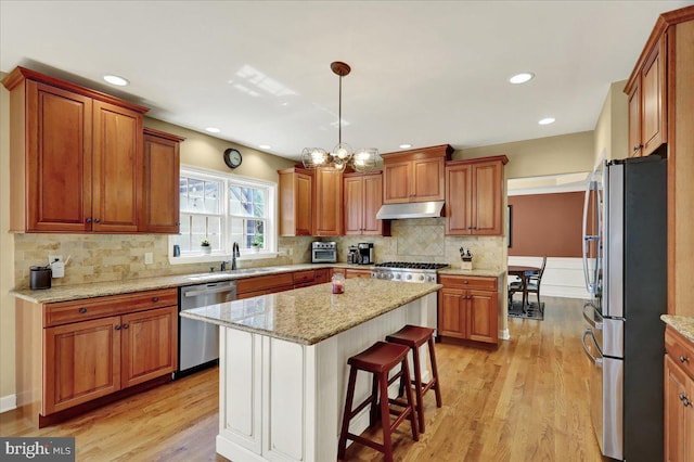 17 N Carolina Ave, Reading, PA 19608 - kitchen featuring appliances with stainless steel finishes, under cabinet range hood, light wood finished floors, a sink, and brown cabinets