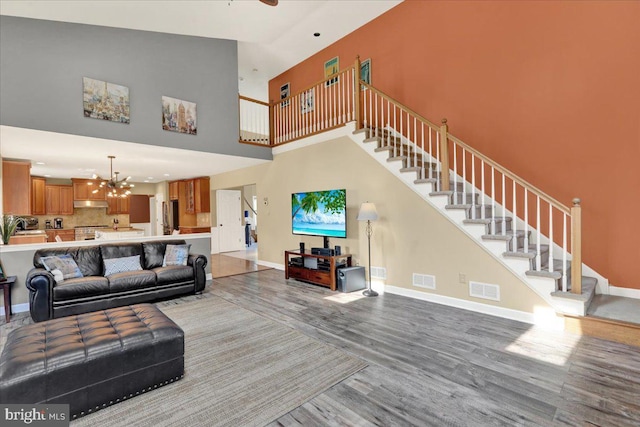 17 N Carolina Ave, Reading, PA 19608 - living room with light wood finished floors, a towering ceiling, a chandelier, stairs, and baseboards