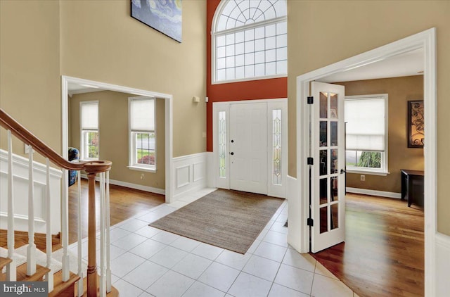 17 N Carolina Ave, Reading, PA 19608 - foyer featuring stairs, plenty of natural light, tile patterned flooring, a towering ceiling, and a wainscoted wall