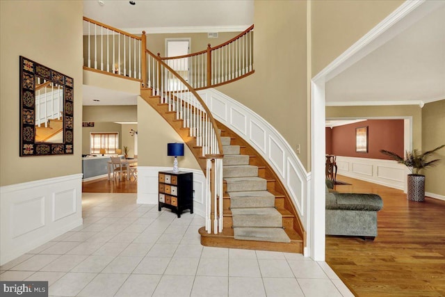 17 N Carolina Ave, Reading, PA 19608 - stairs with crown molding, a decorative wall, a wainscoted wall, wood finished floors, and a high ceiling