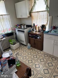 14 3rd Ave, Baltimore, MD 21225 - kitchen featuring white range with gas stovetop, white cabinets, and plenty of natural light