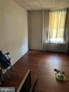 14 3rd Ave, Baltimore, MD 21225 - empty room with radiator, wood finished floors, and a drop ceiling