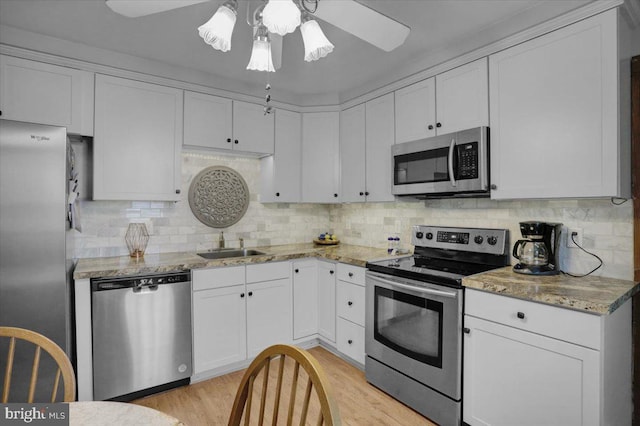 1322 Brooke Blvd, Reading, PA 19607 - kitchen with stainless steel appliances, a sink, a ceiling fan, and white cabinetry