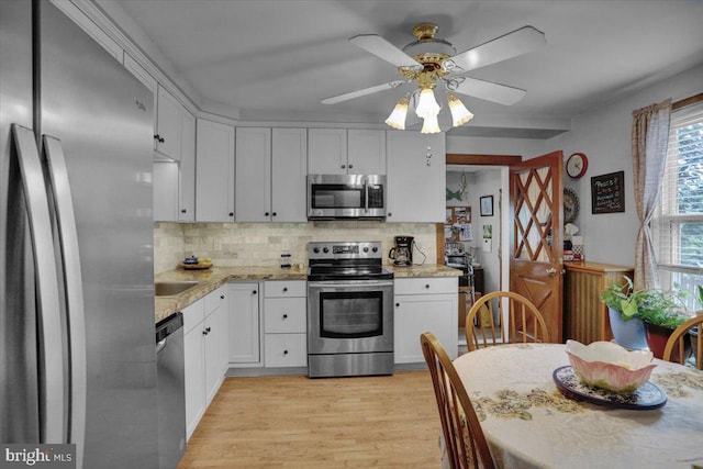 1322 Brooke Blvd, Reading, PA 19607 - kitchen featuring stainless steel appliances, a ceiling fan, tasteful backsplash, light wood-style flooring, and white cabinetry