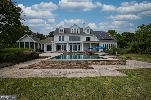 6153 Long Point Rd, Neavitt, MD 21652 - back of house with roof mounted solar panels, a patio area, an outdoor pool, a lawn, and a chimney