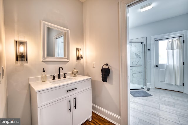 6153 Long Point Rd, Neavitt, MD 21652 - bathroom featuring a marble finish shower, vanity, baseboards, and wood finished floors