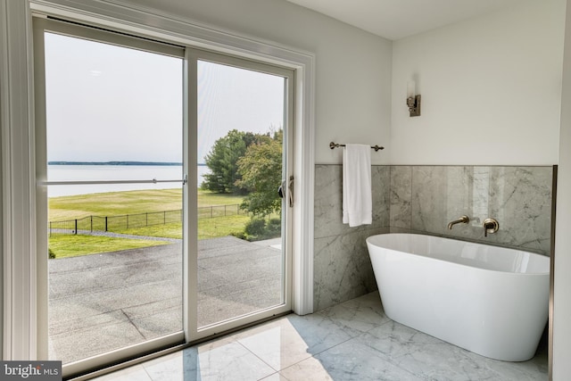 6153 Long Point Rd, Neavitt, MD 21652 - bathroom with a water view, a freestanding tub, tile walls, marble tiled floors, and wainscoting