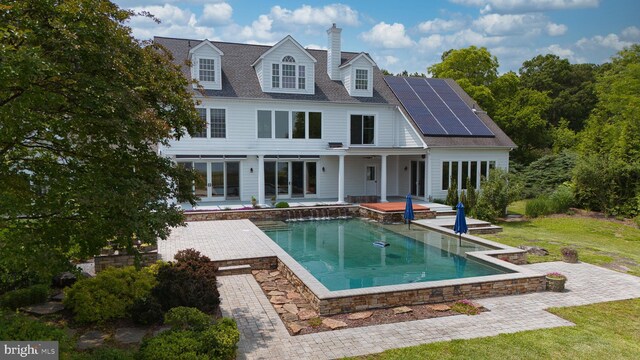 6153 Long Point Rd, Neavitt, MD 21652 - back of house with roof mounted solar panels, a patio area, and an outdoor pool