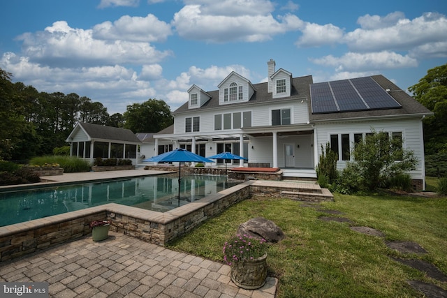 6153 Long Point Rd, Neavitt, MD 21652 - rear view of property with a patio area, an outdoor pool, solar panels, a yard, and a chimney