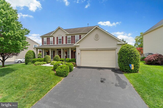 5631 Jordan Blvd, New Market, MD 21774 - view of front of property featuring covered porch, asphalt driveway, a front lawn, and a garage
