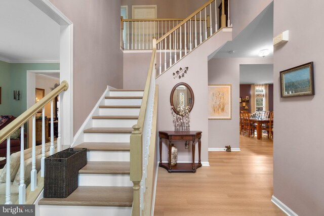 5631 Jordan Blvd, New Market, MD 21774 - staircase featuring wood finished floors, baseboards, crown molding, and a high ceiling