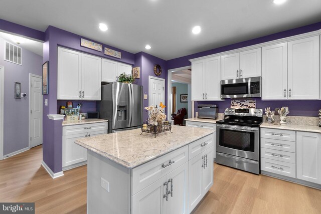 5631 Jordan Blvd, New Market, MD 21774 - kitchen featuring appliances with stainless steel finishes, light wood-type flooring, a kitchen island, white cabinetry, and recessed lighting