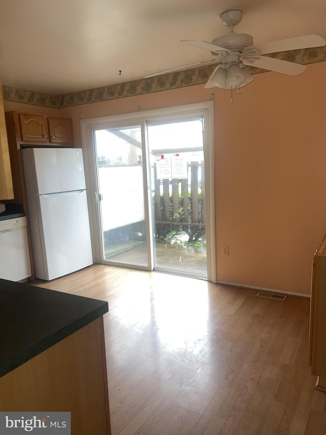 8265 Vosges Rd, Windsor Mill, MD 21244 - kitchen featuring white appliances, a ceiling fan, light wood-style floors, and dark countertops