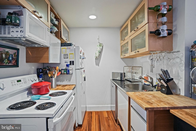 1413 Hopkins St NW, Washington, DC 20036 - kitchen featuring white appliances, wooden counters, light wood-type flooring, a sink, and baseboards