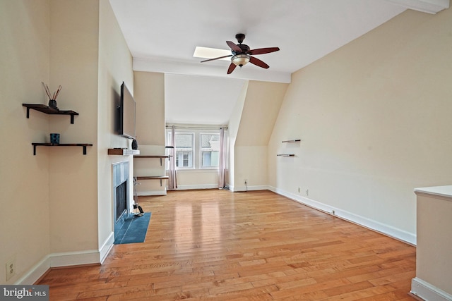 1413 Hopkins St NW, Washington, DC 20036 - unfurnished living room featuring ceiling fan, a fireplace with flush hearth, wood finished floors, baseboards, and lofted ceiling