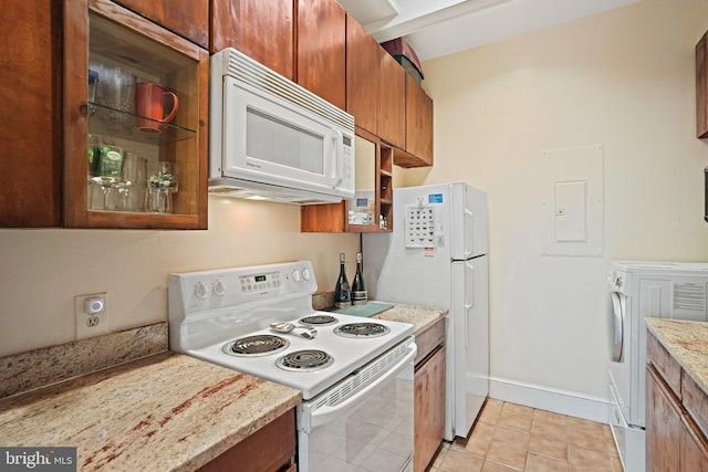 1413 Hopkins St NW, Washington, DC 20036 - kitchen with white appliances, washer / dryer, brown cabinetry, electric panel, and light tile patterned floors