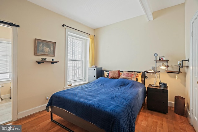 1413 Hopkins St NW, Washington, DC 20036 - bedroom with wood finished floors, baseboards, beam ceiling, and a barn door