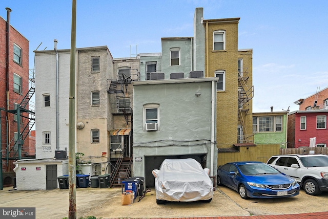 1413 Hopkins St NW, Washington, DC 20036 - view of building exterior featuring an attached garage, concrete driveway, cooling unit, and stairway