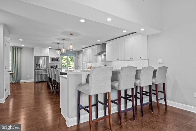 2 Woodfern Ave, Ewing, NJ 08628 - kitchen with appliances with stainless steel finishes, wall chimney exhaust hood, recessed lighting, white cabinetry, and a kitchen breakfast bar