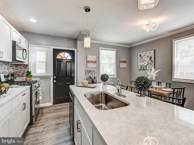 3812 Midheights Rd, Baltimore, MD 21215 - kitchen with appliances with stainless steel finishes, a sink, light wood-type flooring, light stone countertops, and decorative light fixtures
