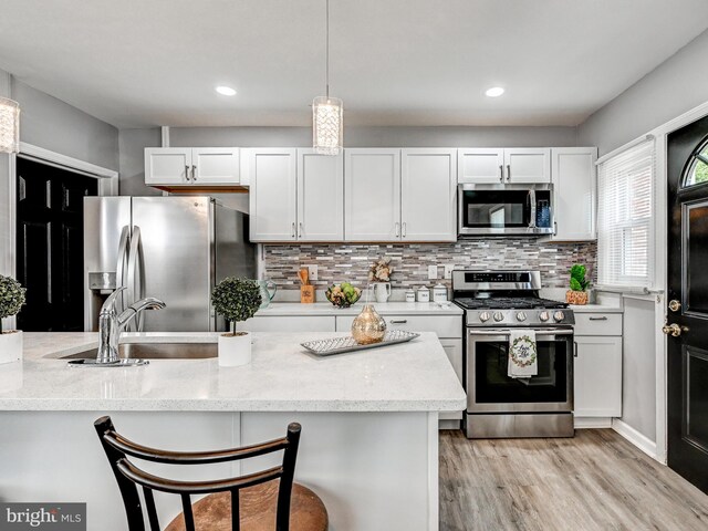 3812 Midheights Rd, Baltimore, MD 21215 - kitchen featuring appliances with stainless steel finishes, white cabinetry, light wood-type flooring, decorative backsplash, and recessed lighting