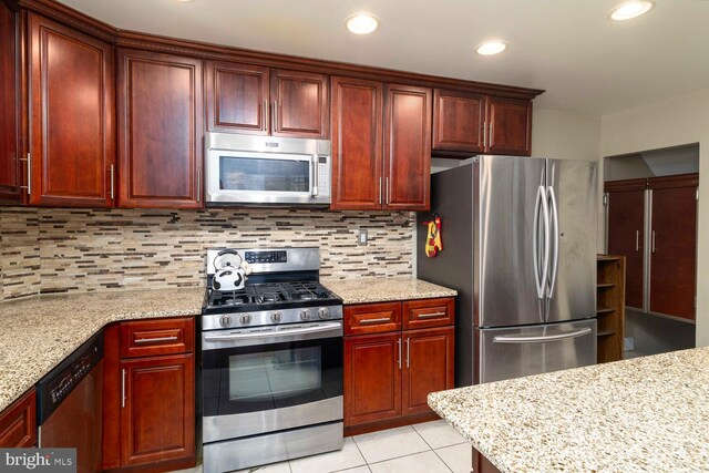 8627 Gilbert St, Philadelphia, PA 19150 - kitchen with stainless steel appliances, dark brown cabinets, light tile patterned flooring, decorative backsplash, and light stone counters