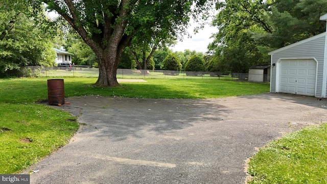12 Thruway Dr, Colora, MD 21917 - view of yard featuring a garage, asphalt driveway, and view of wooded area