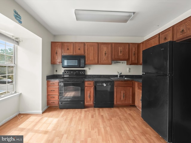 7677 E Arbory Ct Unit 231, Laurel, MD 20707 - kitchen featuring black appliances, dark countertops, brown cabinets, light wood-style flooring, and a sink