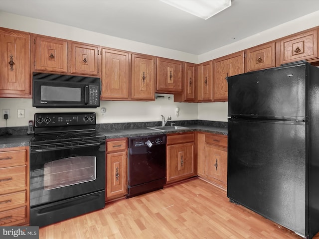 7677 E Arbory Ct Unit 231, Laurel, MD 20707 - kitchen featuring black appliances, a sink, dark countertops, light wood finished floors, and brown cabinetry