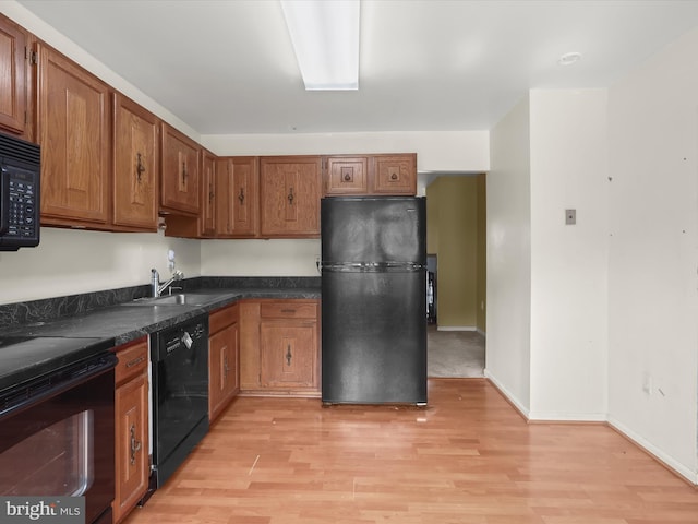 7677 E Arbory Ct Unit 231, Laurel, MD 20707 - kitchen with black appliances, a sink, dark countertops, light wood-type flooring, and brown cabinetry