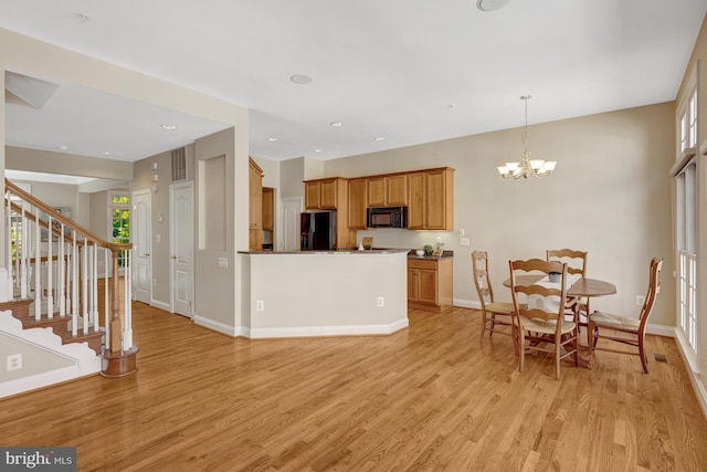 1650 Colonial Hills Dr, Mclean, VA 22102 - kitchen featuring black appliances, light wood-type flooring, a chandelier, decorative light fixtures, and a peninsula