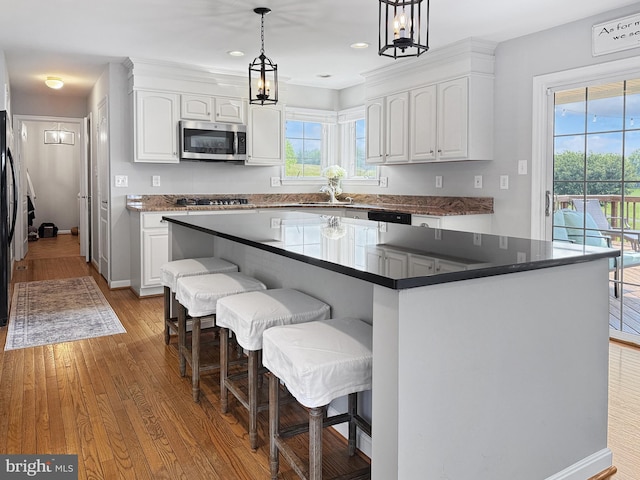 13225 Manor S, Mount Airy, MD 21771 - kitchen featuring stainless steel microwave, white cabinets, gas cooktop, wood finished floors, and a center island