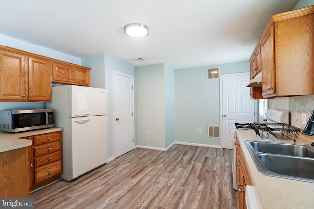 403 S Brynwood Dr, Browns Mills, NJ 08015 - kitchen with stainless steel microwave, freestanding refrigerator, stove, under cabinet range hood, and light wood finished floors