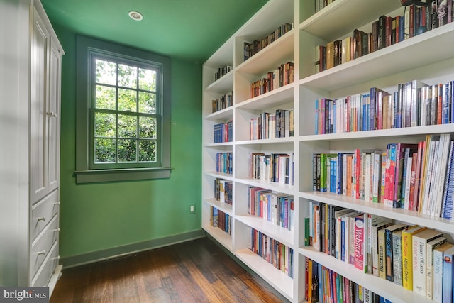 323 N Patrick St, Alexandria, VA 22314 - unfurnished room featuring wall of books, baseboards, and dark wood-style flooring