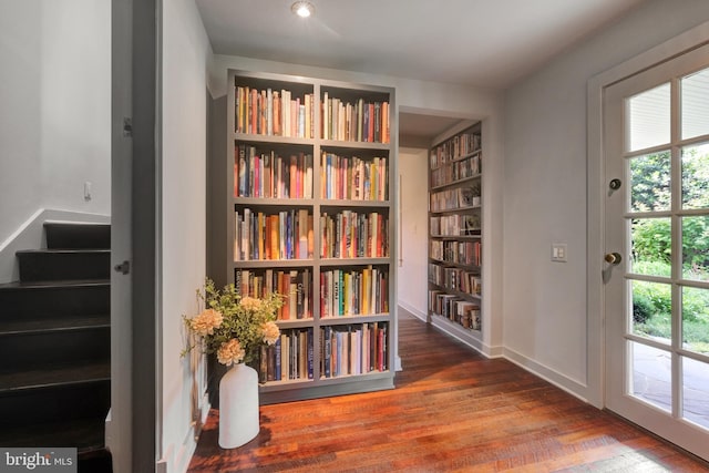 323 N Patrick St, Alexandria, VA 22314 - sitting room with wood finished floors, wall of books, stairs, and baseboards